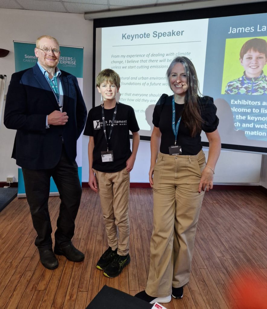 A photo of Somerset Member of Youth Parliament at the Somerset Sustainable Futures Event, with a couple of the other delegates on either side of him.