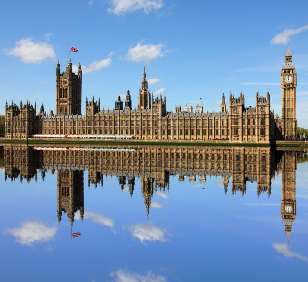 The House of Commons on a bright sunny day, reflecting perfectly in the thames