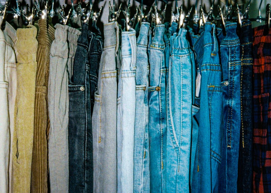 Jeans and trousers hanging from a rack